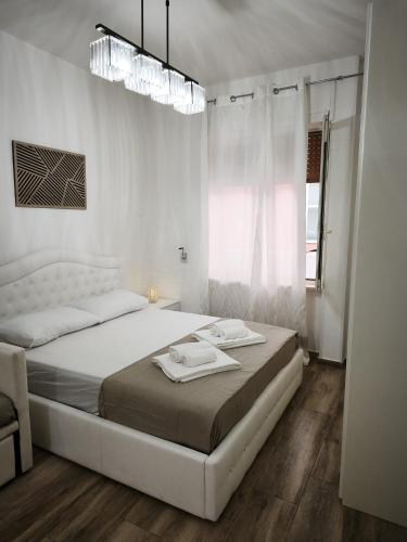 a white bedroom with a bed with two towels on it at B&B Ampelea in Gallipoli