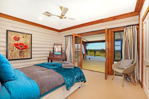 a bedroom with a bed and a chair and a window at The Lodge at Eagle Rock Farm, in Mandemar