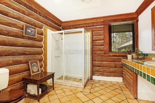 a bathroom with wooden walls and a shower and a sink at The Lodge at Eagle Rock Farm, in Mandemar