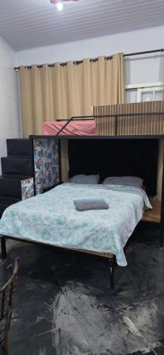 a large bed in a room with a bed frame at Kitnet próximo ao shopping in Campo Grande