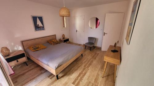 a bedroom with a bed and a table and a chair at Villa Nausicaa in Hyères