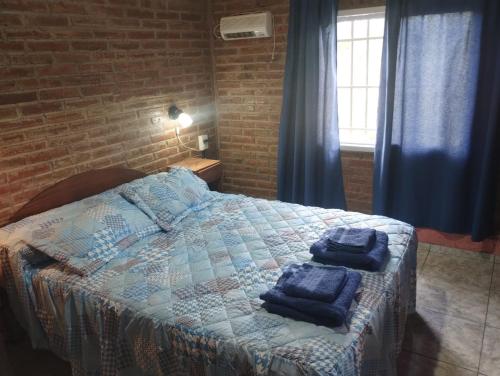 a bedroom with a bed with blue towels on it at Cabaña María Lourdes in Maipú
