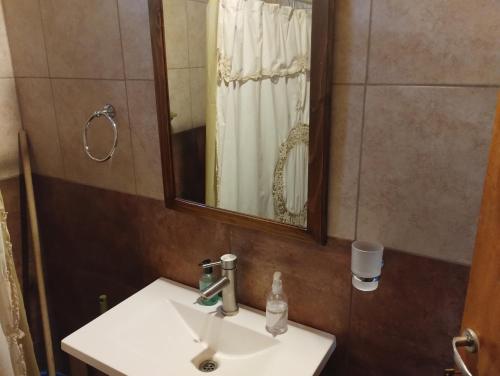 a bathroom with a sink and a mirror at Cabaña María Lourdes in Maipú