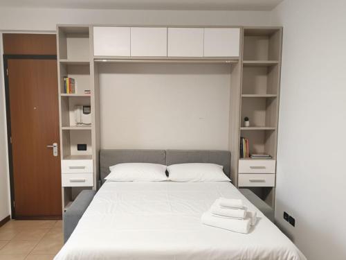 a bedroom with a bed with white sheets and shelves at Casa Maribel in Salionze