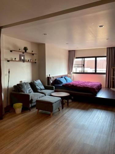 a living room with a couch and a bed at Thaiger House Studios in Bangkok
