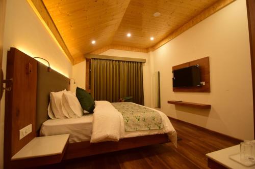 a hotel room with a bed and a television at Private Villa Alpine Escape 6BHK in Manāli