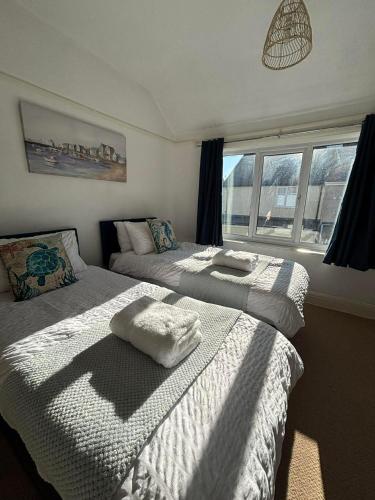 a bedroom with two beds with towels on them at Rhos on sea home in Llandrillo-yn-Rhôs