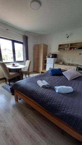 a bedroom with a large bed with two towels on it at Studio Sanja Knez in Soko Banja