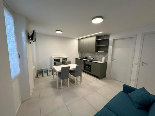 a kitchen and living room with a table and chairs at White Suite Lakeside in Colonno