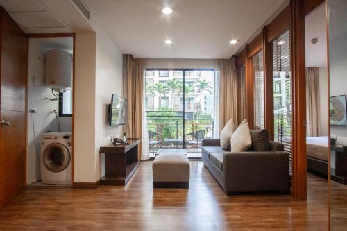 a living room with a couch and a washing machine at Amanta Hotel & Residence Ratchada in Bangkok