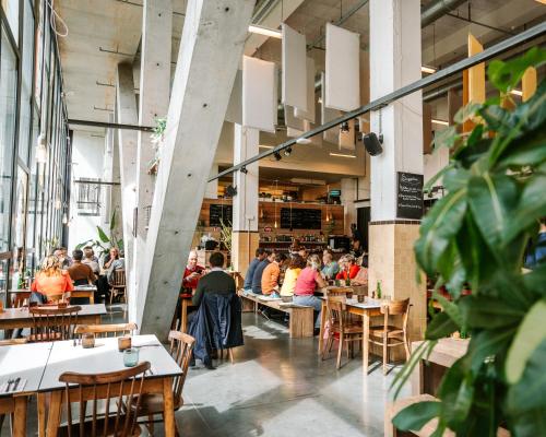 a group of people sitting at tables in a restaurant at De Hoorn in Leuven