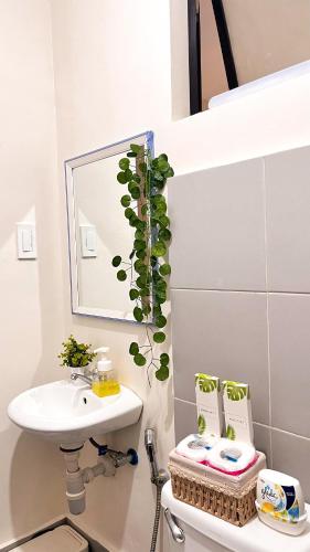 a bathroom with a sink and a mirror and a toilet at The HappyNest Tagum in Tagum
