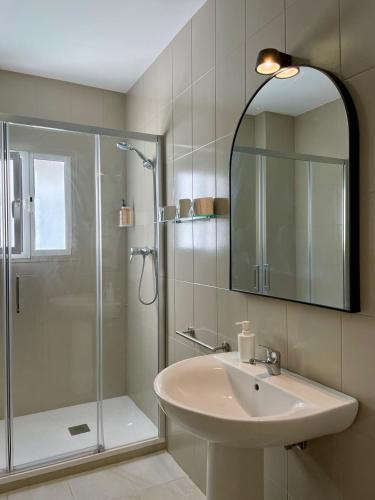 a bathroom with a sink and a shower with a mirror at BOHEMIA SANLUCAR in Sanlúcar de Barrameda