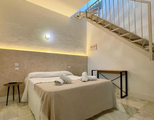 a bedroom with a bed with two towels on it at BOHEMIA SANLUCAR in Sanlúcar de Barrameda