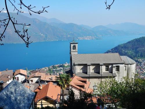 a town with a clock tower and a body of water at Casa Angelino in Cannobio