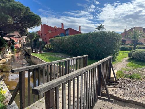 a wooden bridge over a river next to a house at studio coquet et tranquille in Porquerolles