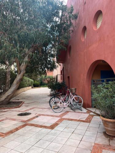 a bike parked next to a red building at studio coquet et tranquille in Porquerolles