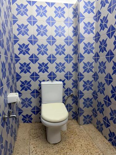 a bathroom with a toilet and blue and white tiles at Utu house in Zanzibar City