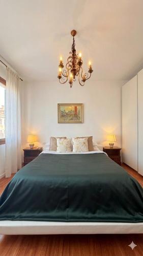 a bedroom with a large bed with a chandelier at 威尼斯Mestre火车站明亮舒适便捷整套公寓Casa Marco in Marghera