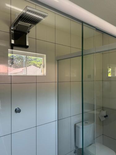 a bathroom with a glass shower with a toilet at HOTEL SAYMON - Cafelândia PARANÁ in Cafelândia