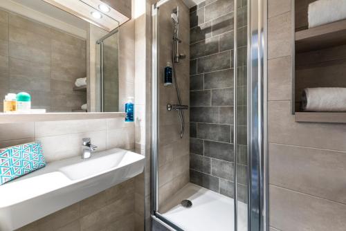 a bathroom with a sink and a shower at Hotel Le Lumière in Lyon