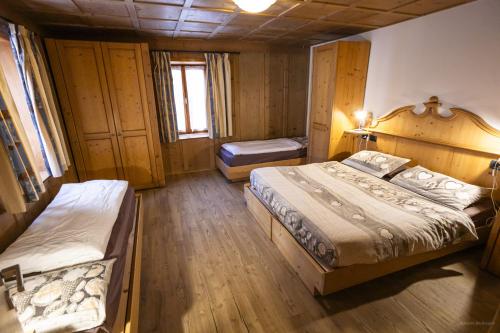 a bedroom with two beds in a room at Appartamenti dei Maerins in Pozza di Fassa