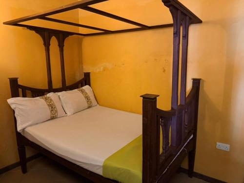 a bed in a room with a wooden canopy bed at Utu house in Zanzibar City