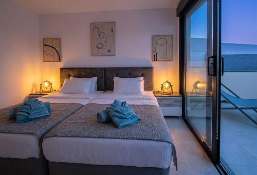 two beds in a hotel room with towels on them at VillasRoyale Rex - no steps, easy access, heated pool & BBQ in Meloneras