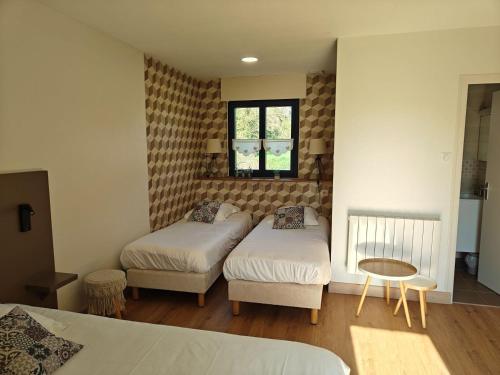 a bedroom with two beds and a window at Studios - Location de vacances Le Trécelin in Plévenon