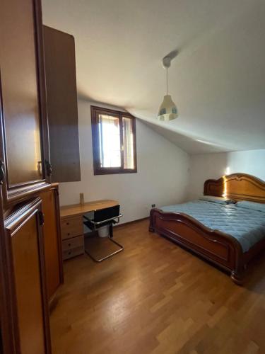 a bedroom with a bed and a desk in it at Casa Rustica - Camere in Torri di Quartesolo