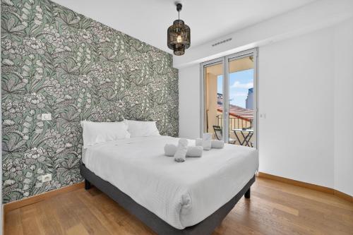 a bedroom with a bed with a floral accent wall at 1 chambre - Ascenseur - Balcon - Proche du Palais in Cannes