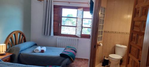 a bedroom with a bed and a toilet and a window at Pensión San Cristóbal by Bossh! Hotels in Cuenca