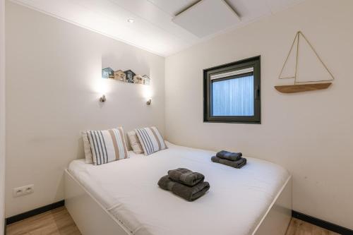 a white bed in a room with a window at Houseboat-Oostende in Ostend