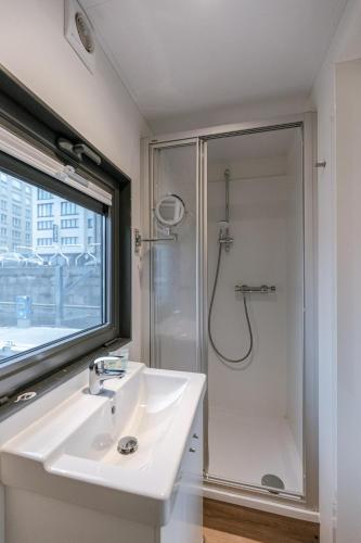 a white bathroom with a sink and a shower at Houseboat-Oostende in Ostend