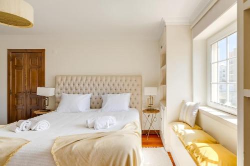 a white bedroom with a large bed and a window at Grande Villa com Piscina Privada | Ericeira in Ericeira