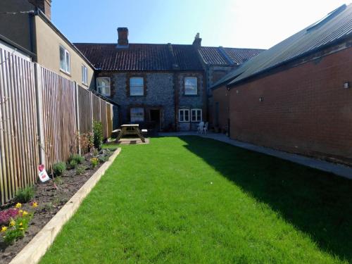a backyard of a house with a grass yard at Annies, 30 Station Road in Sheringham
