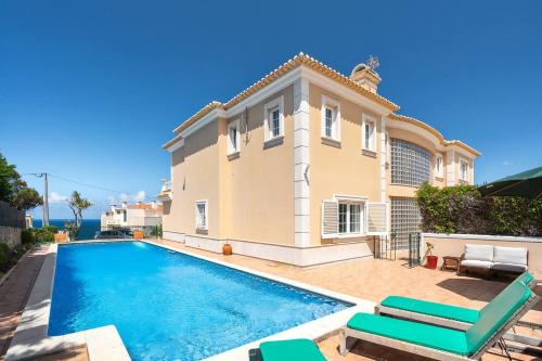 a villa with a swimming pool in front of a house at Grande Villa com Piscina Privada | Ericeira in Ericeira