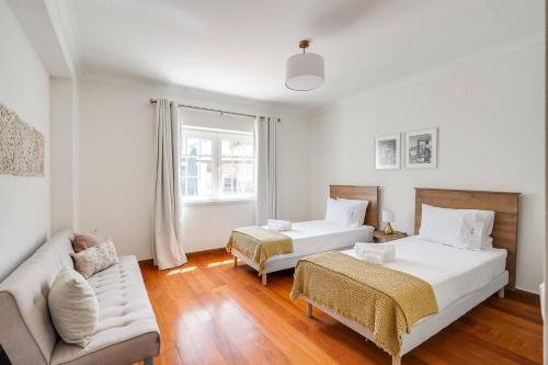 a living room with two beds and a couch at Grande Villa com Piscina Privada | Ericeira in Ericeira