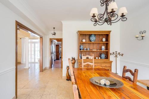 a dining room with a table and a chandelier at Grande Villa com Piscina Privada | Ericeira in Ericeira
