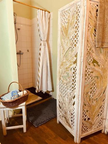 a shower stall with a shower curtain and a basket at Casa Arthur, Transylvanian heritage house in Richişu