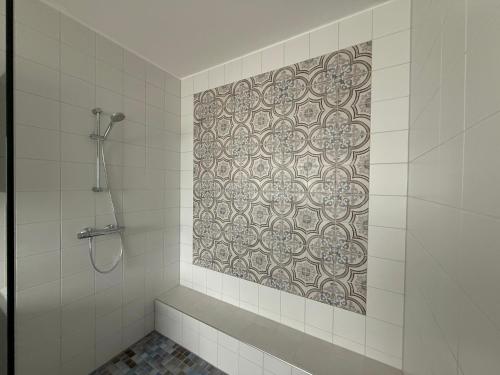 a bathroom with a shower and a tile wall at Ferienhaus Pirat Störtebeker Dangast in Dangast