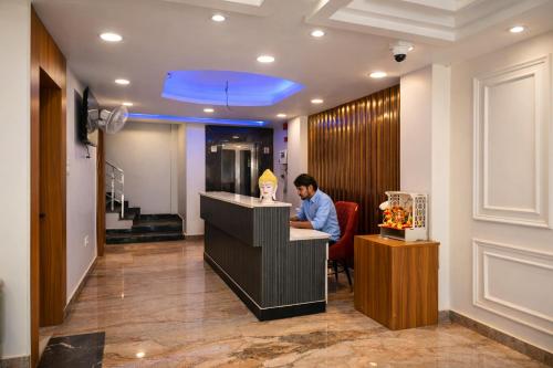 a man sitting at a counter in a restaurant at Hotel Mariott Inn in Prayagraj
