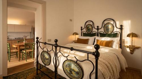 a bedroom with a large bed and a kitchen at Edoardo Historic House in Gubbio