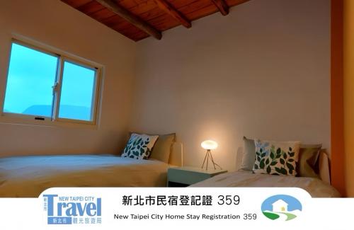 two beds in a room with a window at Shan Cheng Guesthouse in Ruifang