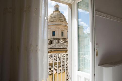 a view of a building from a window at Casa Camelia - Cathedral View Apartment, 90m from Duomo in Noto
