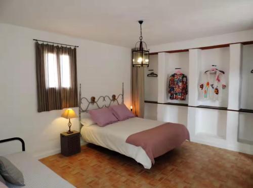 a bedroom with a bed with pink pillows and a window at El aceitunal private pool in Puerto del Rosario