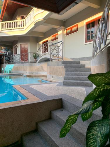 a house with a swimming pool and stairs at Scan House Apartment in Karon Beach