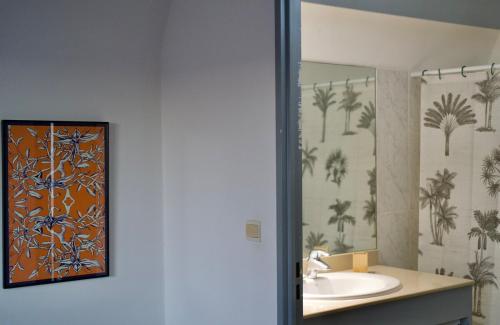 a bathroom with a sink and a mirror at Le Frangipanier in La Possession