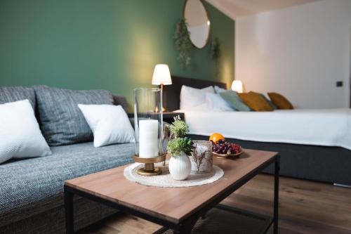 a living room with a couch and a table with a candle at Lakeside Lodge mit Seeblick am Kranichsee in Goslar
