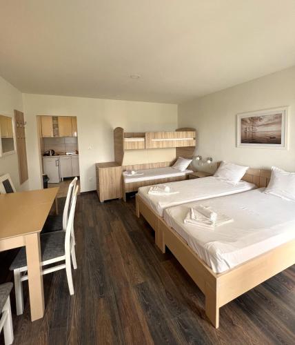 a room with two beds and a desk and a table at Apartments Gloria in Budva